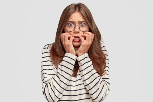 scared neurotic female model looks anxiously feels fear something dressed casual sweater isolated white wall terrific student afraids passing exam reaction concept - Psicología de la Persuasión. Gatillos Antiguos para Pantallas Modernas