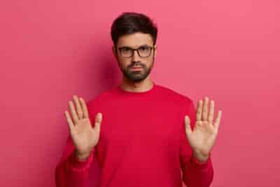 Cómo Elegir el Nombre de tu Marca: Guía Definitiva de Naming para Negocios que Quieren Arrasar en Internet (y en Google) 2 photo european man with thick stubble makes stop gesture hold sign pulls palms looks seriously has determined expression asks calm down wears red sweater glasses - Cómo Elegir el Nombre de tu Marca: Guía Definitiva de Naming para Negocios que Quieren Arrasar en Internet (y en Google)